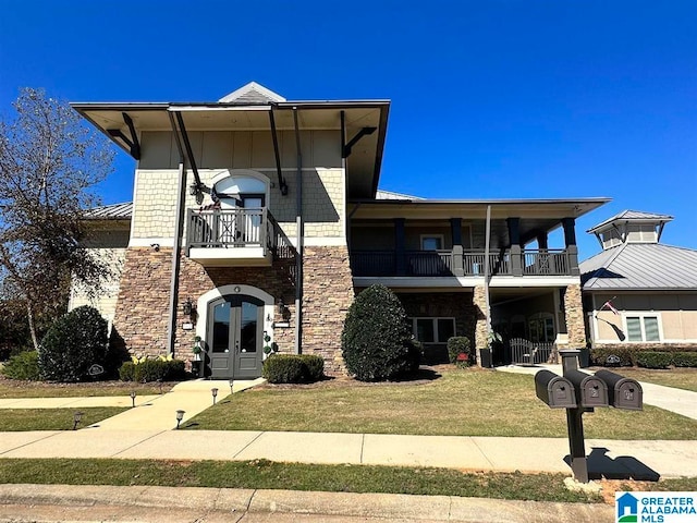 view of front of home featuring a front yard, french doors, and a balcony