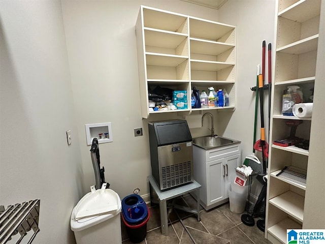 laundry room with sink, cabinets, washer hookup, electric dryer hookup, and dark tile patterned flooring