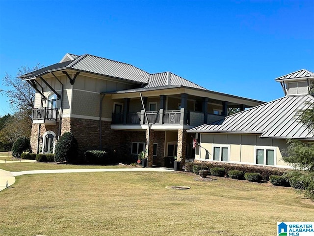 view of front of property featuring a front yard and a balcony