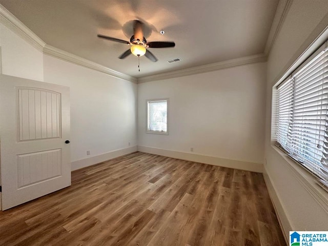 empty room with ceiling fan, hardwood / wood-style floors, and ornamental molding