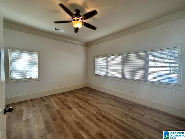 unfurnished room featuring hardwood / wood-style flooring, ornamental molding, and a wealth of natural light