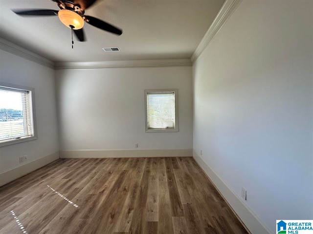 empty room with ceiling fan, wood-type flooring, and ornamental molding