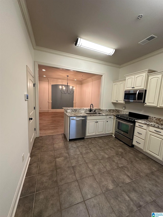 kitchen with a chandelier, appliances with stainless steel finishes, hanging light fixtures, and crown molding