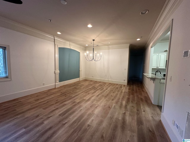 unfurnished dining area with hardwood / wood-style floors, a notable chandelier, and ornamental molding