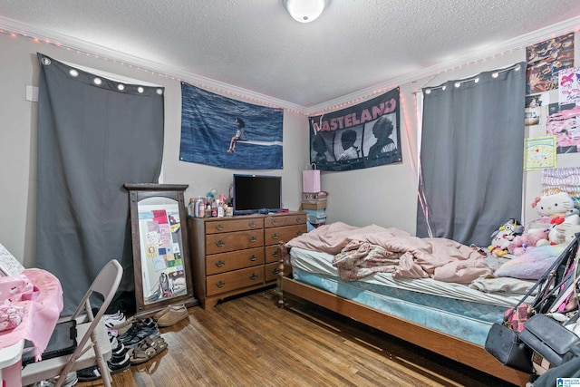 bedroom featuring a textured ceiling, hardwood / wood-style flooring, and crown molding