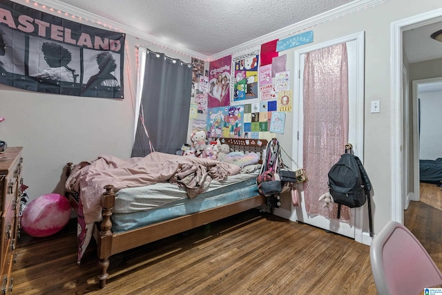 bedroom with crown molding, hardwood / wood-style floors, and a textured ceiling