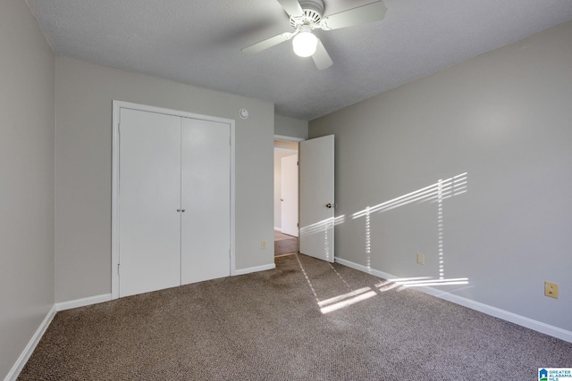 unfurnished bedroom featuring ceiling fan, carpet floors, a textured ceiling, and a closet