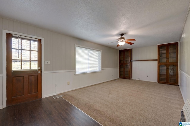 foyer with hardwood / wood-style floors, ceiling fan, and a textured ceiling