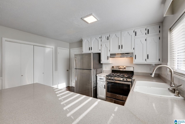 kitchen with white cabinets, a textured ceiling, stainless steel appliances, and sink