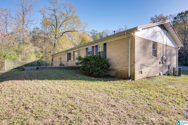 view of home's exterior with a yard and central AC unit