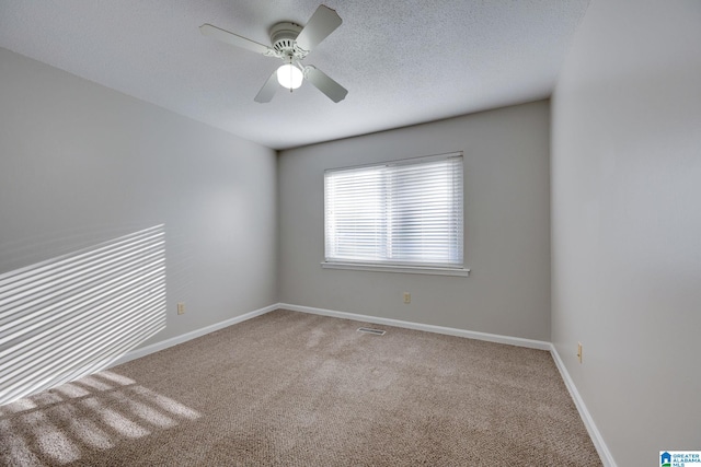 carpeted spare room with ceiling fan and a textured ceiling