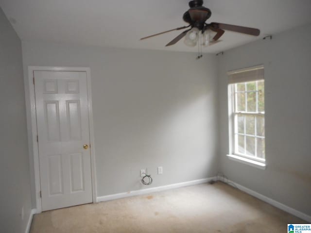 unfurnished room with ceiling fan and light carpet