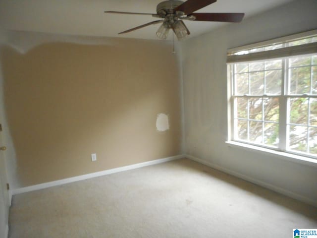 carpeted spare room featuring ceiling fan