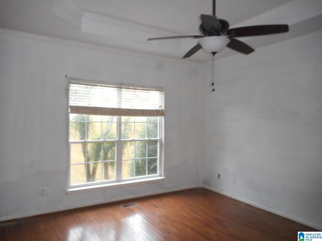 spare room featuring dark hardwood / wood-style floors, ceiling fan, and crown molding