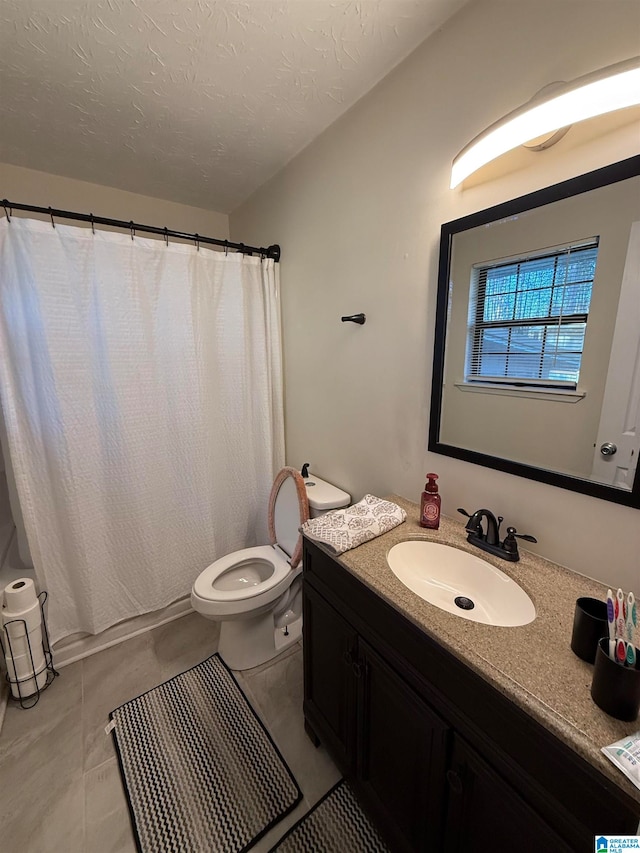 bathroom with vanity, tile patterned floors, toilet, a textured ceiling, and walk in shower