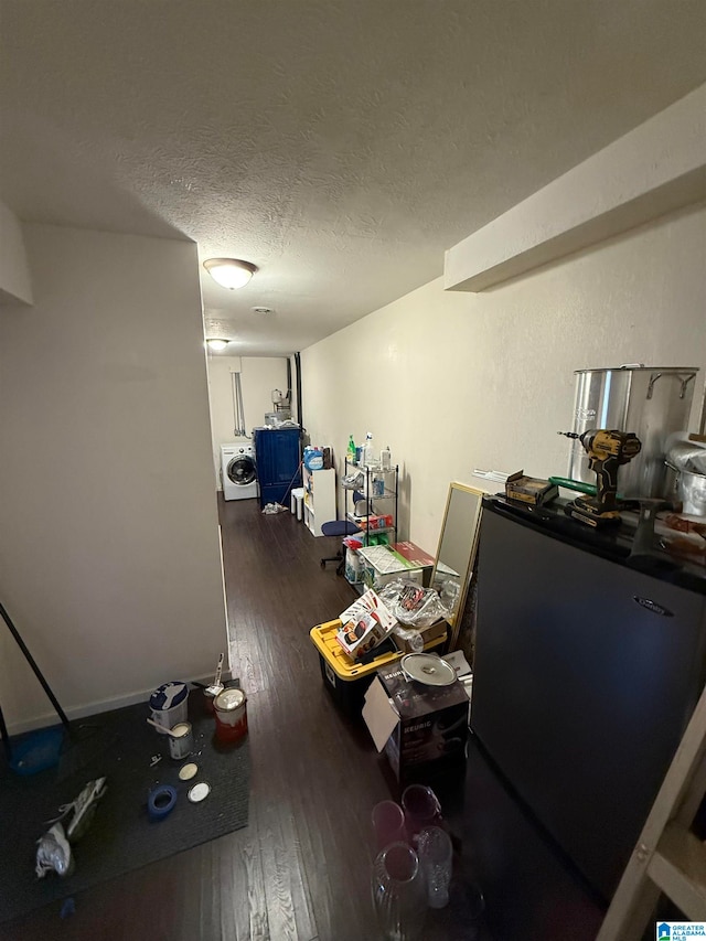 interior space with dark hardwood / wood-style flooring, a textured ceiling, and washer / clothes dryer