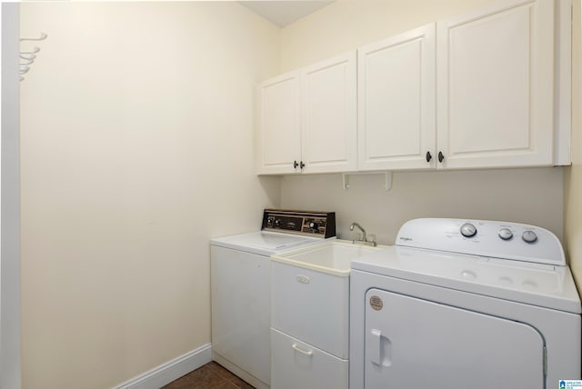 laundry room with cabinets, washer and dryer, and dark tile patterned flooring