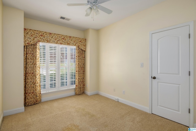 spare room with light colored carpet and ceiling fan