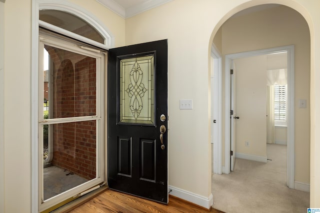 entryway with light hardwood / wood-style floors and ornamental molding