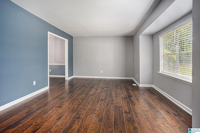 unfurnished room with dark wood-type flooring