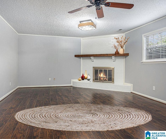 unfurnished living room featuring ornamental molding, a brick fireplace, wood-type flooring, and a textured ceiling