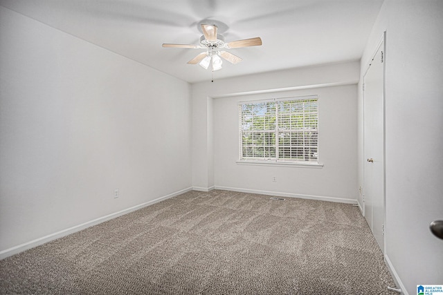 unfurnished room with ceiling fan and carpet