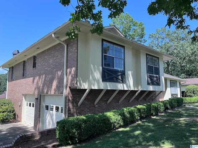 view of side of property featuring a garage and a yard