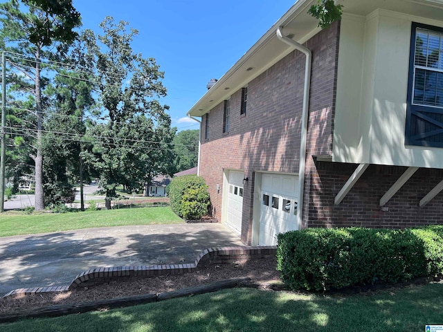 view of home's exterior with a garage and a lawn