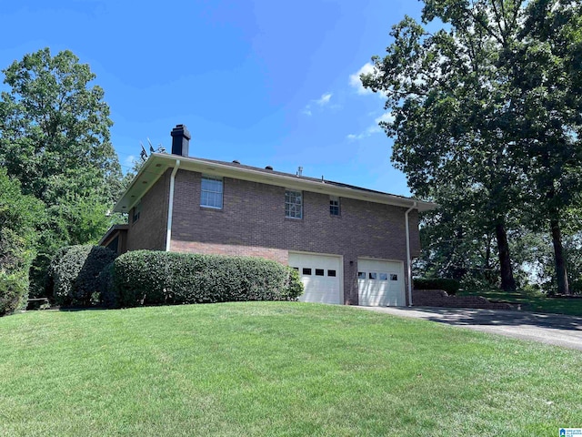 view of side of property featuring a garage and a lawn