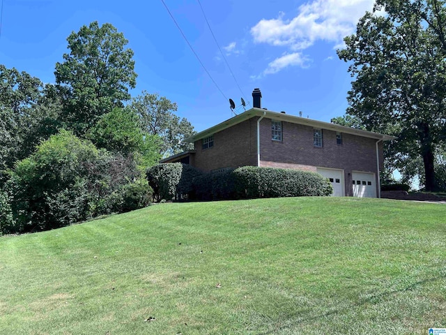 view of side of property featuring a garage and a lawn