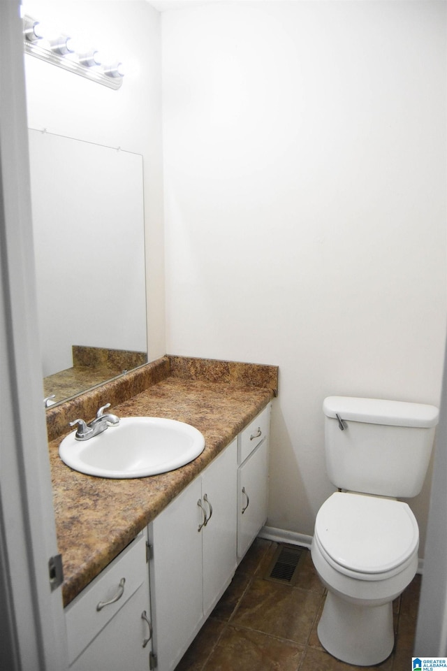 bathroom featuring tile patterned floors, vanity, and toilet