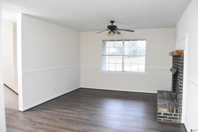 unfurnished living room featuring ceiling fan, dark wood-type flooring, and a brick fireplace