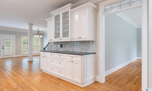 kitchen featuring white cabinets, an inviting chandelier, crown molding, and light hardwood / wood-style flooring