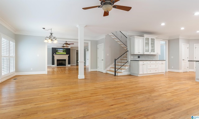 unfurnished living room with light wood-type flooring and ornamental molding