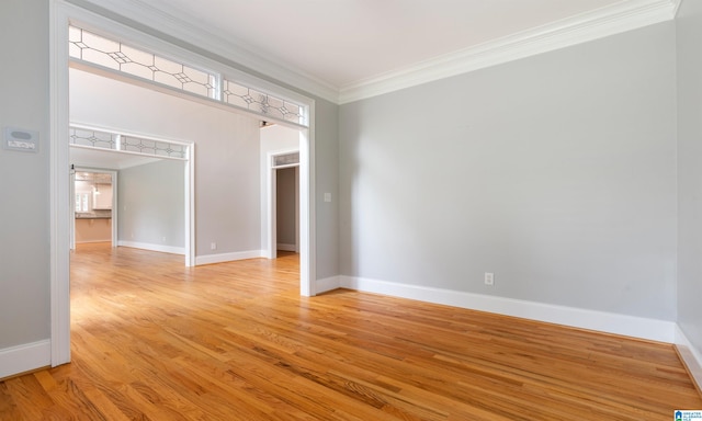 empty room with crown molding and light hardwood / wood-style flooring