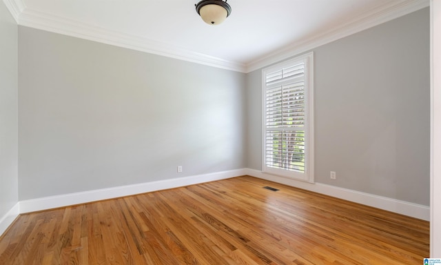 unfurnished room with wood-type flooring and ornamental molding