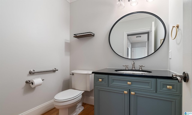 bathroom with hardwood / wood-style floors, vanity, toilet, and ornamental molding