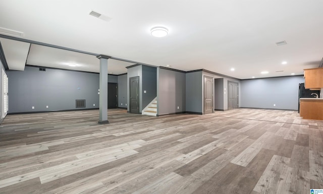 basement with hardwood / wood-style flooring and crown molding