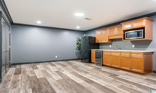 kitchen with black refrigerator, light wood-type flooring, ornamental molding, beverage cooler, and stainless steel microwave