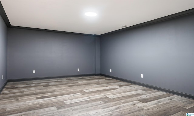 unfurnished room with light hardwood / wood-style floors and crown molding