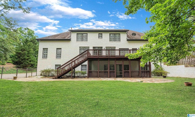 rear view of house with a wooden deck, a sunroom, and a yard