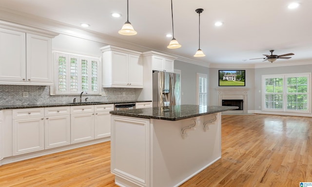 kitchen featuring a wealth of natural light, white cabinets, light hardwood / wood-style floors, and appliances with stainless steel finishes