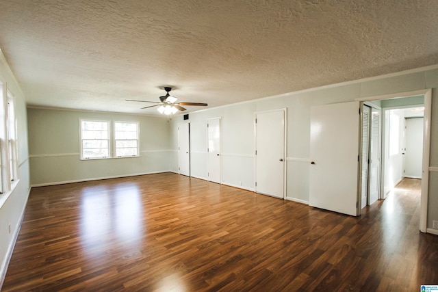 unfurnished bedroom featuring a textured ceiling, dark hardwood / wood-style flooring, two closets, and ceiling fan