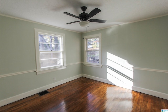 empty room with ceiling fan, dark hardwood / wood-style floors, and ornamental molding