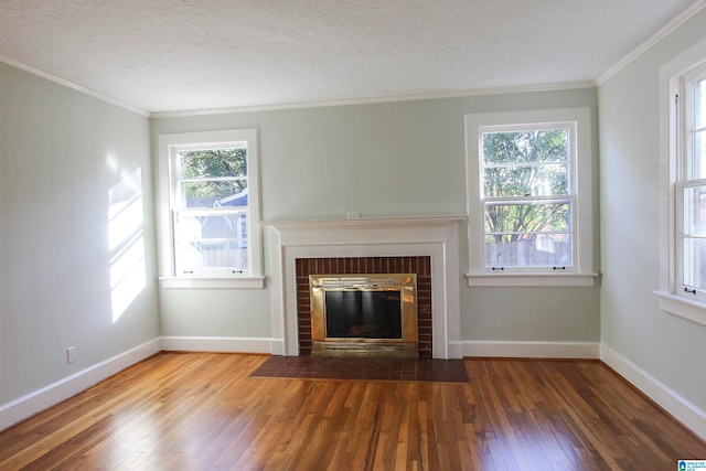 unfurnished living room with a wealth of natural light, a fireplace, and wood-type flooring