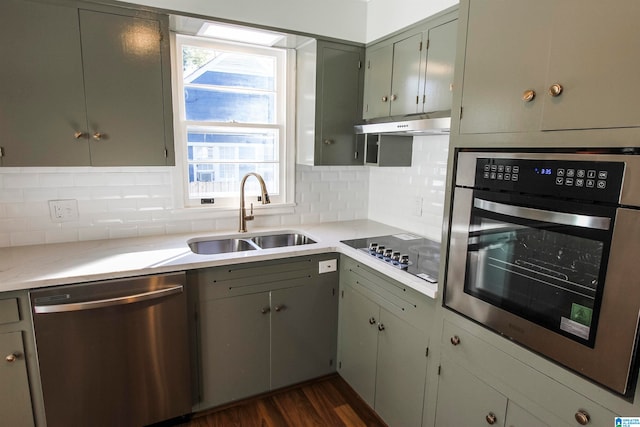 kitchen with decorative backsplash, dark hardwood / wood-style flooring, sink, and appliances with stainless steel finishes