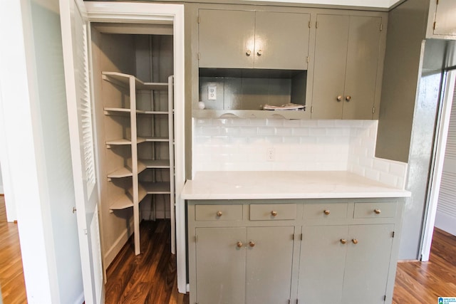 interior space featuring gray cabinetry, decorative backsplash, and dark wood-type flooring