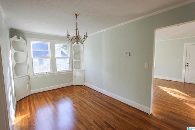 unfurnished room with hardwood / wood-style floors, an inviting chandelier, and ornamental molding