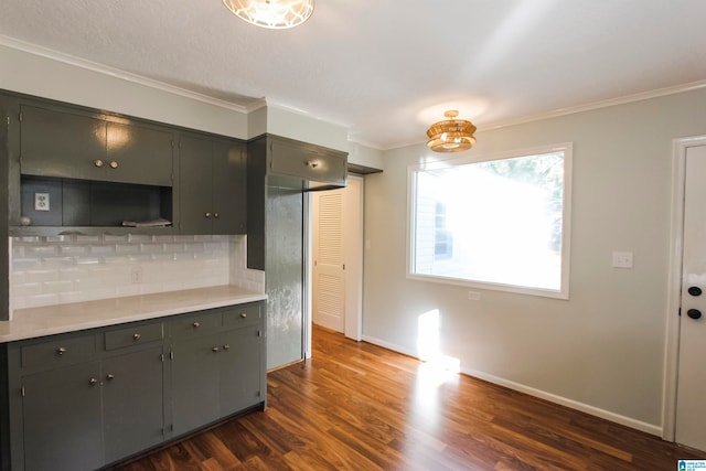 kitchen with dark hardwood / wood-style flooring, ornamental molding, and backsplash