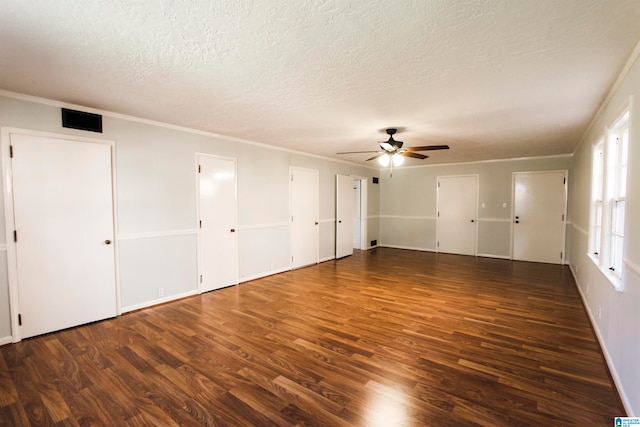 unfurnished bedroom featuring dark hardwood / wood-style floors, ceiling fan, and multiple closets